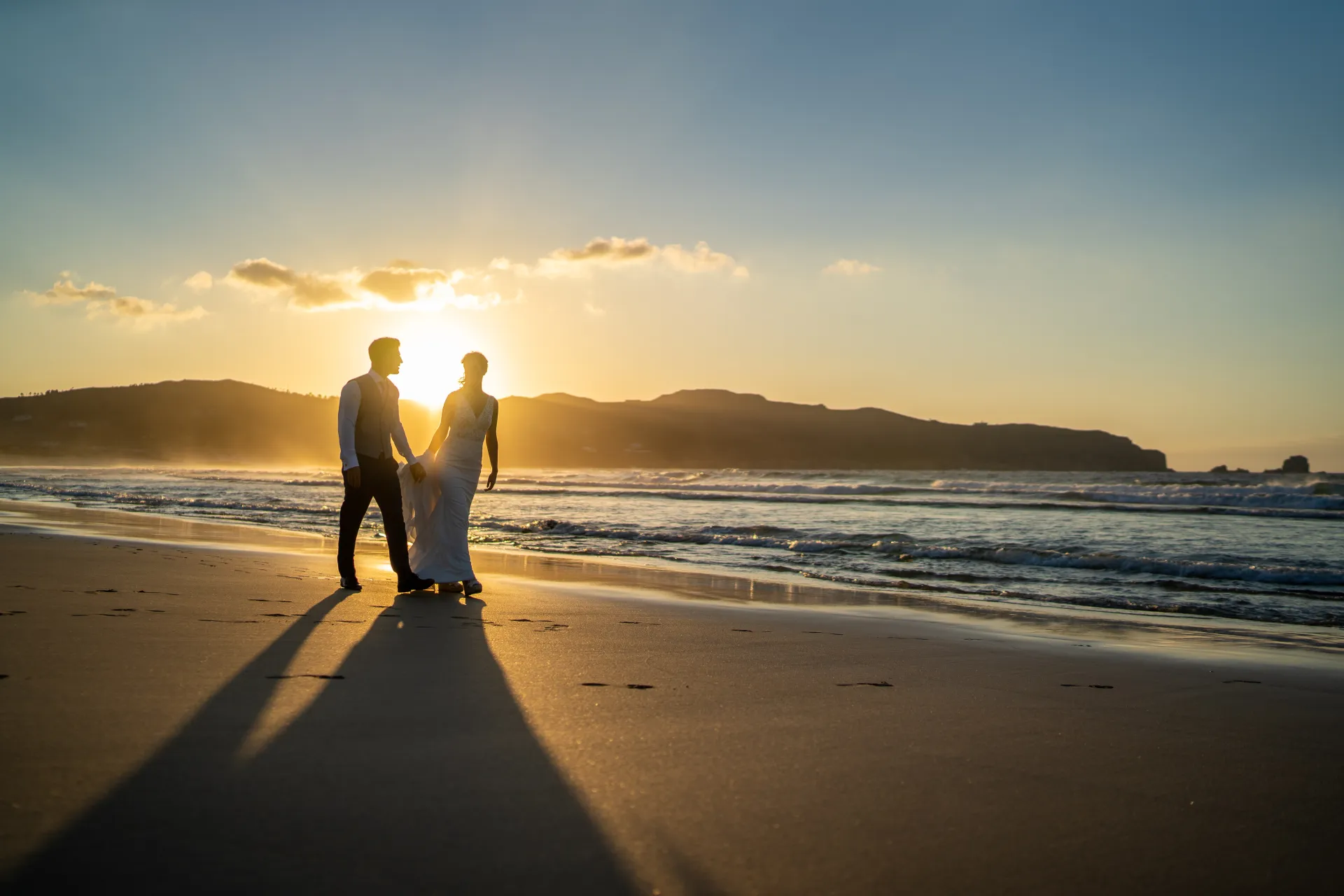 Pareja de novios en la playa al atardecer filmada por Visualtec Film Studio en Galicia